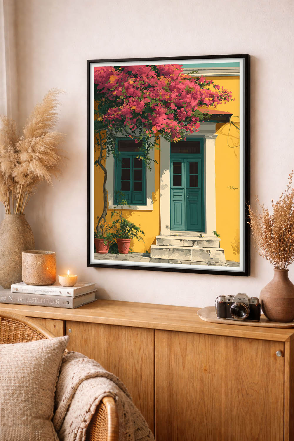 Framed artwork of a colorful door with pink flowers on a wall above a wooden cabinet.