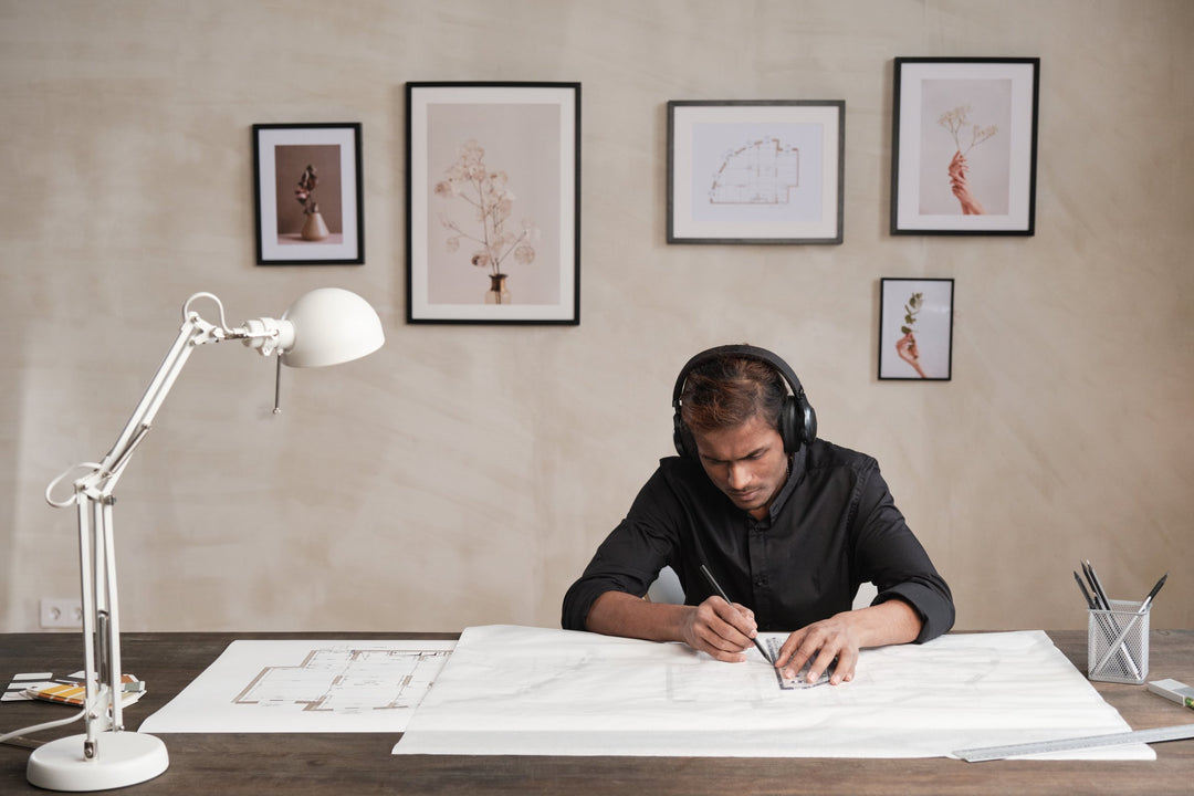 an architect and interior designer working on his project having art prints as background